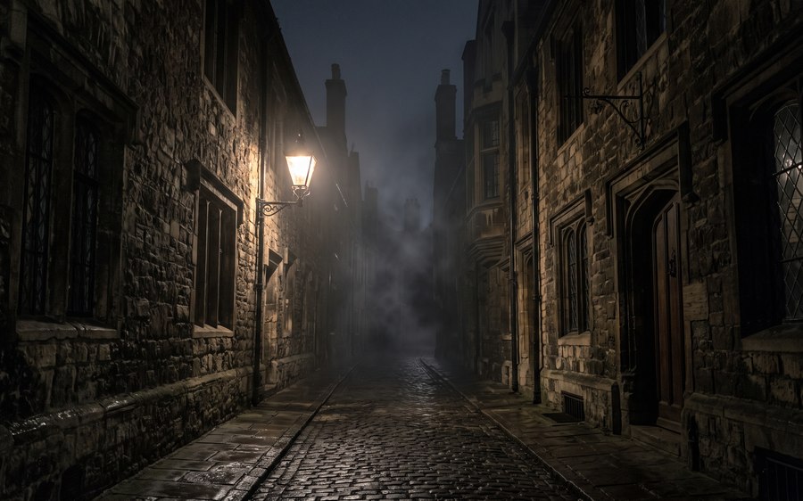 Dark cobblestone alley at night